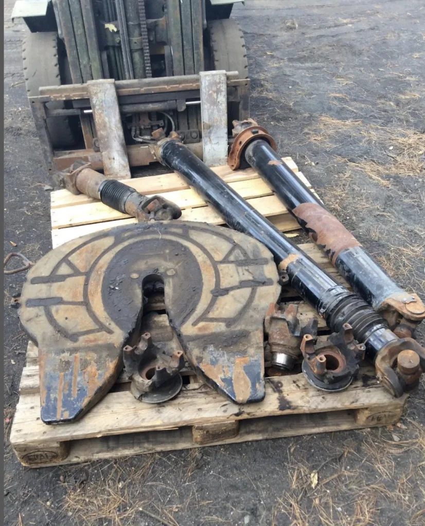 Metal truck components with old coating and surface buildup before blasting